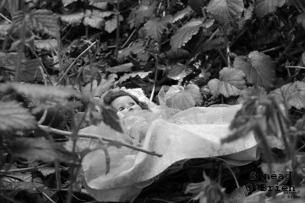 Black & white photo of porcelain doll in the woods: sleeping beauty
